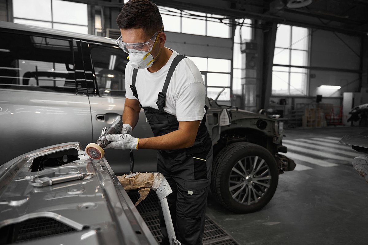 Male cleaning surface of auto, prepare for repair